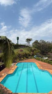a large blue swimming pool with a water tower in the background at Hotel Lago Alphaville in Apucarana