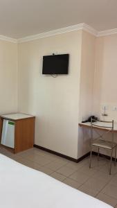 a room with a tv on a white wall at Hotel Lago Alphaville in Apucarana +7 photos