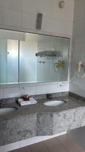 a bathroom with two sinks and a large mirror at Hotel Lago Alphaville in Apucarana