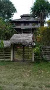 an old house with a straw roof and a fence at Casa Amare Bolivar Zapotal Island 14pax 7hab in Muisne