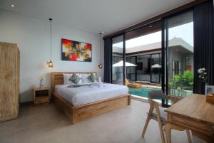 a bedroom with a bed and a table and a desk at Vila Padma Bali at Sayan - Ubud, A Trishula Collection in Ubud +60 photos