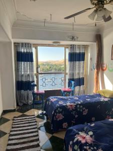 a bedroom with two beds and a large window at Aisha guesthouse in Aswan