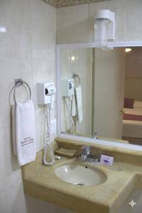 a bathroom with a sink and a mirror at Hotel Santa Rosa in Oaxaca City