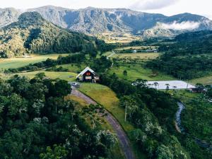a house on a hill with mountains in the background at Chalé Exclusivo com Spa e Vista Mágica, Top Urubici in Urubici