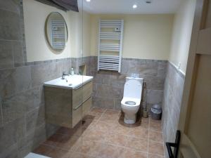 a bathroom with a white toilet and a sink at Au repos du Dourmeur in Saint-Évarzec +5 photos