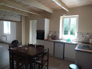 a kitchen with a wooden table and a table and chairs at Au repos du Dourmeur in Saint-Évarzec