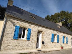 an old stone building with blue shutters at Au repos du Dourmeur in Saint-Évarzec