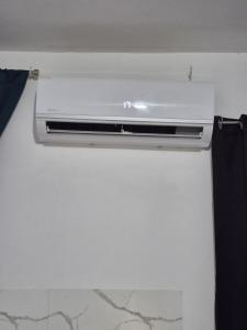 a white air conditioner sitting on top of a wall at OMY Apartments Nagua 1B in Nagua +15 photos