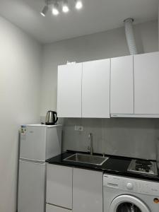 a kitchen with white cabinets and a sink and a dishwasher at Grigor's Guestgouse in Yerevan