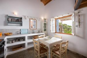 a kitchen with a table and chairs and a window at Lithea Villas and Studios by the Sea in Aghios Petros Alonissos +89 photos