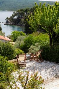 two chairs and a picnic table in a garden at Lithea Villas and Studios by the Sea in Aghios Petros Alonissos