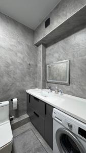 a bathroom with a washing machine and a sink at Luxury & City Central Apartment & Great Atmosphere in Almaty