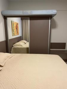 Un dormitorio con una cama y una puerta corrediza de vidrio. en Park Veredas Apto 705, en Rio Quente 41 fotos más