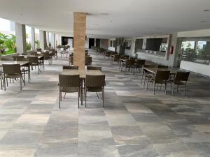 a dining area with tables and chairs in a building at Park Veredas Apto 705 in Rio Quente