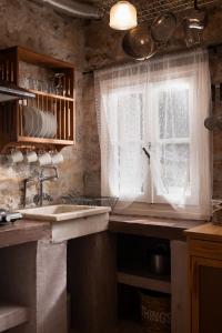 a kitchen with a sink and a window at Lithea Villas and Studios by the Sea in Aghios Petros Alonissos