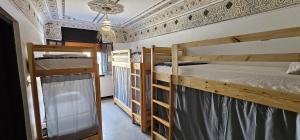 two bunk beds in a room with a ceiling at Habibi Hostel in Taghazout