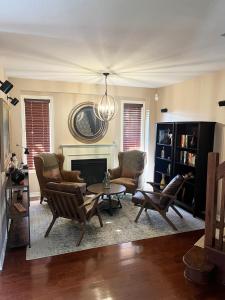 a living room with chairs and a table and a fireplace at Luxury Chalet-Walk to Beach/Village w Mtn View in Blue Mountains