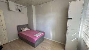 a small room with a pink ottoman in the corner at Hostelida Konya in Konya