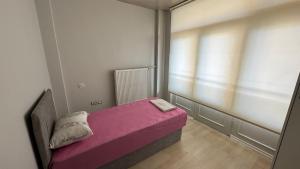 a small bedroom with a pink bed and a window at Hostelida Konya in Konya +46 photos