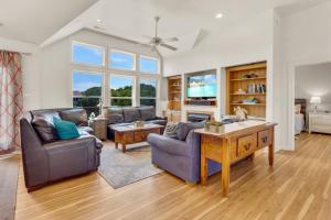 a living room with two couches and a table at 2070 - Sol Mates in Duck