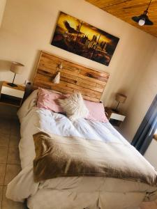 a bedroom with a large bed with a wooden headboard at Cabañas El bosque DLM in Uspallata
