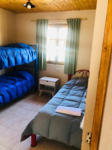 a bedroom with two bunk beds and a window at Cabañas El bosque DLM in Uspallata