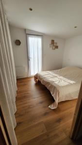 Un dormitorio con una cama y suelo de madera. en Ploe, en Ploeren