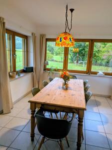 a dining room with a wooden table and a light fixture at Eulennest im Ferienhaus an der Holzecke in Schnelldorf