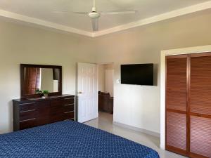 a bedroom with a bed and a dresser and a television at Portmore Country Club Cozy1Bedroom Retreat in Portmore