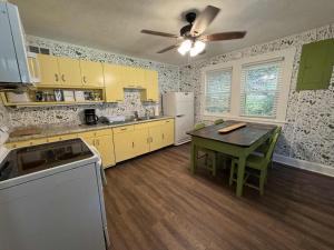 a kitchen with yellow cabinets and a table and a ceiling fan at The Renovated Farmhouse at Seneca Rocks in Seneca Rocks