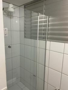 a shower with a glass door in a bathroom at Águas da Serra Apto 520A in Rio Quente