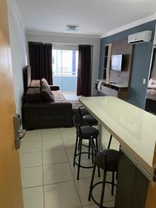 a living room with a couch and a table and chairs at Águas da Serra Apto 520A in Rio Quente