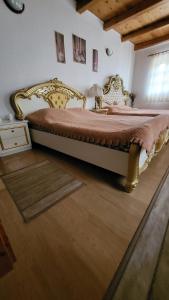 a bedroom with a large bed with a wooden floor at Jupiter in Rimetea