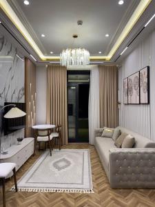 a living room with a couch and a table at Nest One Luxe, Элитные апартаменты с террасой и панорамным видом 067 in Tashkent
