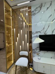 a dressing room with a white chair and a desk at Nest One Luxe, Элитные апартаменты с террасой и панорамным видом 067 in Tashkent