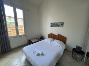 a bedroom with a bed with two towels on it at Petite maison cœur de ville de La Teste de Buch in La Teste-de-Buch