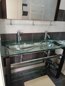 a glass counter with two sinks in a bathroom at Petite maison cœur de ville de La Teste de Buch in La Teste-de-Buch +4 photos