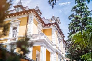 um edifício amarelo com um gambrel em Villa Helvetia em Merano