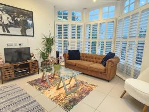 Una sala de estar con un sofá y un televisor. en 3-Bedroom Luxury House, Oxford, Free Parking, WiFi, Garden, en Oxford