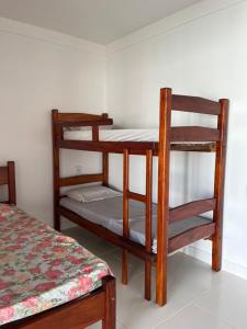 two bunk beds in a room with a bed at Casa ponta da tulha in Ilhéus