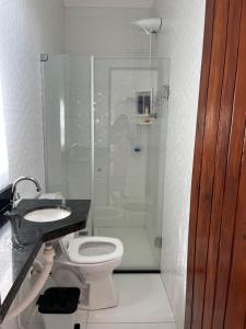 a bathroom with a shower and a toilet and a sink at Casa ponta da tulha in Ilhéus +20 photos