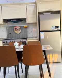 a kitchen with a table and chairs and a refrigerator at فيلا نجمة الشمال in Um Qeis