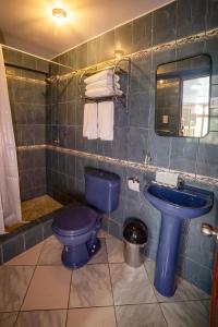 a bathroom with a blue toilet and a sink at Casa Andora in Machu Picchu