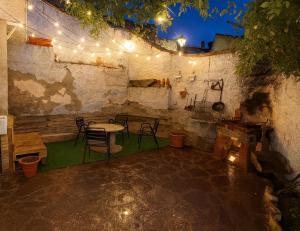 a patio with a table and chairs and lights at CASA LA JUDERÍA in Gea de Albarracín +11 photos