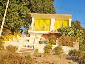 a house with yellow windows and a fence at Esmerada in Aswan