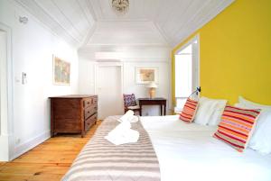 a bedroom with a large bed with a yellow wall at Charming Coastside Villa in Colares