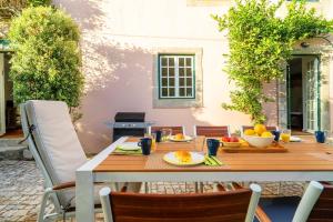 a wooden table with fruit on it on a patio at Charming Coastside Villa in Colares