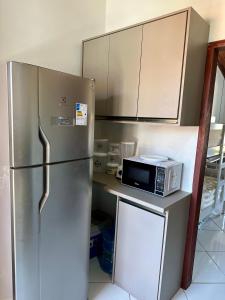 W kuchni znajduje się lodówka ze stali nierdzewnej i kuchenka mikrofalowa. w obiekcie Flat dboa w mieście Jericoacoara
