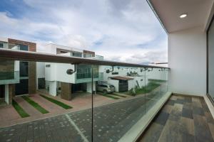 a view from the balcony of a house with glass walls at Casa Adul Chignahuapan in Chignahuapan