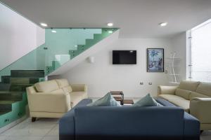 a living room with a couch and a staircase at Casa Adul Chignahuapan in Chignahuapan